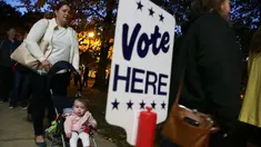 Warga mengajak bayinya saat akan memberikan suara pemilihan presiden AS di Alexandria, Virginia, AS, Selasa (8/11). Warga AS akan menentukan presiden mereka antara Hillary Clinton dan Donald Trump. (AFP Photo/Alex Wong)
