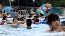 Pengunjung menghabiskan waktu di kolam renang di sebuah taman hiburan di Tokyo, Jepang (19/7). Badan Meteorologi Jepang mengumumkan Jepang tengah, termasuk Tokyo, telah menyelesaikan musim hujan 'Tsuyu'.  (AFP Photo/Toshifumi Kitamura)