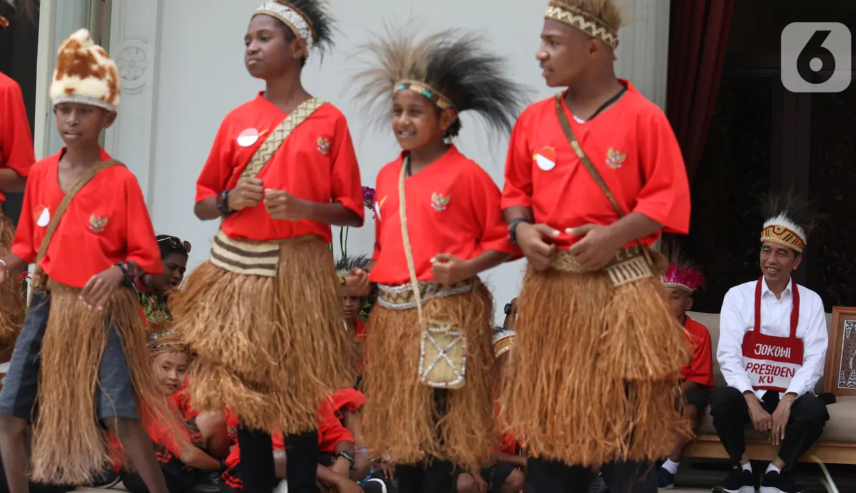 Presiden Joko Widodo atau Jokowi menyaksikan perwakilan anak-anak sekolah dasar dari Papua menari saat diundang ke Istana Merdeka, Jakarta, Jumat (11/10/2019). Pertemuantersebut digelar dalam suasana santai di beranda belakang Istana Merdeka. (Liputan6.com/Angga Yuniar)