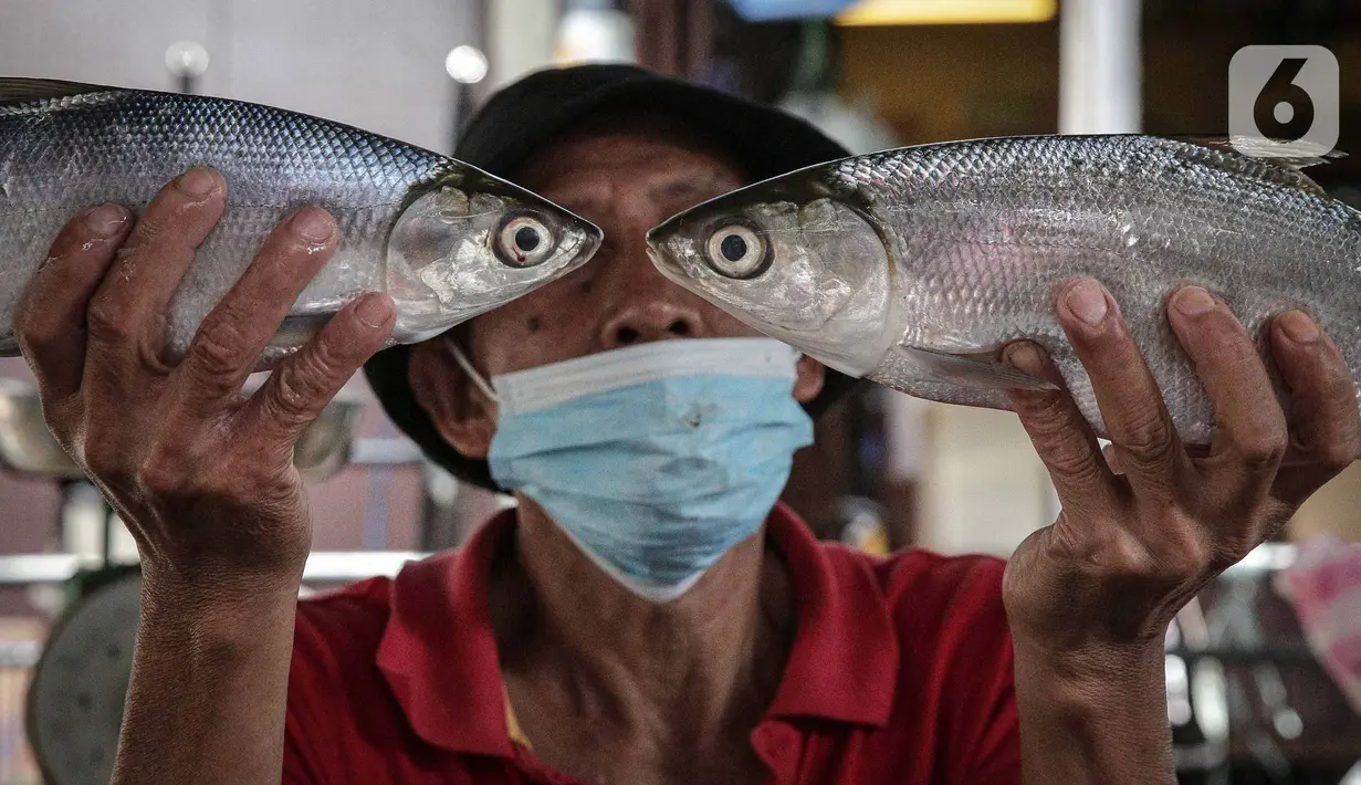 Pedagang menunjukan ikan bandeng di Pasar Petak Sembilan, Glodok, Jakarta, Senin (31/1/2022). Ikan bandeng banyak dibeli jelang Imlek sebagai hidangan saat perayaan Tahun Baru masyarakat Tionghoa itu. (Liputan6.com/Faizal Fanani)