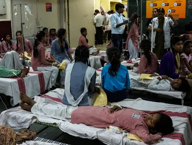 Sejumlah siswi dirawat di rumah sakit menyusul kebocoran gas dari sebuah depot kontainer di New Delhi, Sabtu (6/5). Lebih dari 100 siswa dilarikan ke rumah sakit, di antaranya menderita sesak napas, mual, iritasi mata bahkan pingsan. (Chandan KHANNA/AFP)