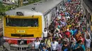 Komuter berjalan di sepanjang peron setelah keluar dari kereta lokal pinggiran kota di Kolkata, India, Senin (1/11/2021). Layanan kereta api kembali normal setelah menerapkan pembatasan yang diberlakukan sebelumnya untuk mengekang penyebaran corona Covid-19. (DIBYANGSHU SARKAR/AFP)