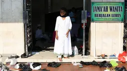 Seorang jemaah berdiri di dekat sampah plastik yang berserakan di area Masjid Istiqlal, Jakarta, Rabu (6/7). Sampah-sampah plastik bekas bungkus sepatu jemaah saat salat Id dibuang begitu saja di halaman masjid. (Liputan6.com/Faizal Fanani)