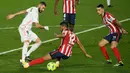 Striker Real Madrid, Karim Benzema, berusaha melewati pemain Atletico Madrid pada laga Liga Spanyol di Stadion Alfredo di Stefano, Minggu (13/12/2020). Real Madrid menang dengan skor 2-0. (AFP/Oscar Del Pozo)