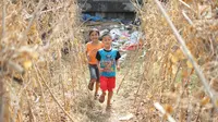 Anak-anak bermain di sekitar tanaman yang mengering bantaran kanal banjir barat (KBB), Jakarta, Kamis (25/7). Musim kemarau panjang yang terjadi di Ibu Kota menyebabkan pekarangan warga di sepanjang KBB mengalami kekeringan. (Liputan6.com/Immanuel Antonius)
