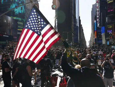 Orang-orang merayakan kemenangan Joe Biden dalam Pilpres AS 2020 di Times Square, New York, Amerika Serikat, Sabtu (7/11/2020). Calon presiden dari Partai Demokrat tersebut keluar sebagai pemenang dan akan menjadi presiden AS ke-46. (AP Photo/Seth Wenig)