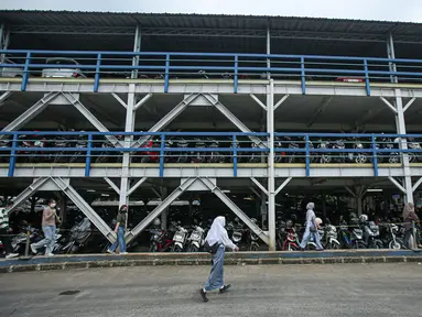 Warga melintas di  Park and Ride Vertikal Terminal Ragunan, Jakarta, Selasa  (29/11/2022). Kantong Parkir Park and Ride ini dibangun untun membantu masyarakat yang ingin menaiki transportasi umum. (Liputan6.com/Faizal Fanani)