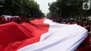 Sejumlah relawan membentangkan Bendera Merah Putih di kawasan jalan Medan Merdeka Selatan, Jakarta, Minggu (20/10/2019). Bendera Merah Putih Sekitar 200 meter dibentangkan jelang pelantikan Presiden-Wapres RI terpilih Joko Widodo-Ma'ruf Amin periode 2019-2024. (Liputan6.com/Herman Zakharia)