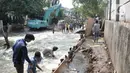 Pekerja menyelesaikan perbaikan tanggul jebol di Kompleks Perumahan Pantai Mutiara, Pluit, Jakarta, Minggu (7/6/2020). Tanggul jebol dengan panjang sekitar 10 meter yang terjadi bersamaan air pasang pada Sabtu (6/6) menyebabkan perumahan tersebut terendam banjir rob. (Liputan6.com/Iqbal S. Nugroho)