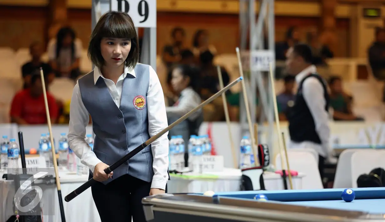 Pebiliar putri DKI Jakarta, Angeline M Ticoalu melihat posisi bola saat laga penyisihan 10 ball PON XIX Jabar di Graha Manggala Siliwangi, Bandung, Kamis (22/9). Angeline berhasil mengalahkan pebiliar Papua, Ari S Wati. (Liputan6.com/Helmi Fithriansyah)