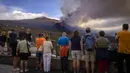 Wisatawan melihat dan mengambil foto gunung berapi yang meletus di Canary, Pulau La Palma, Spanyol, 26 Oktober 2021. Aliran lava baru telah muncul setelah runtuhnya sebagian kawah dan mengancam akan menelan daerah yang sebelumnya tidak terpengaruh. (AP Photo/Emilio Morenatti)