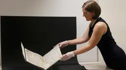 Konservator, Marie Sviergula memegang penggalan naskah Al-Quran tertua di dunia yang ditemukan di Universitas Birmingham, Inggris, Rabu (22/7/2015). Penanggalan radiokarbon menunjukkan manuskrip itu berusia setidaknya 1.370 tahun. (REUTERS/Peter Nicholls)