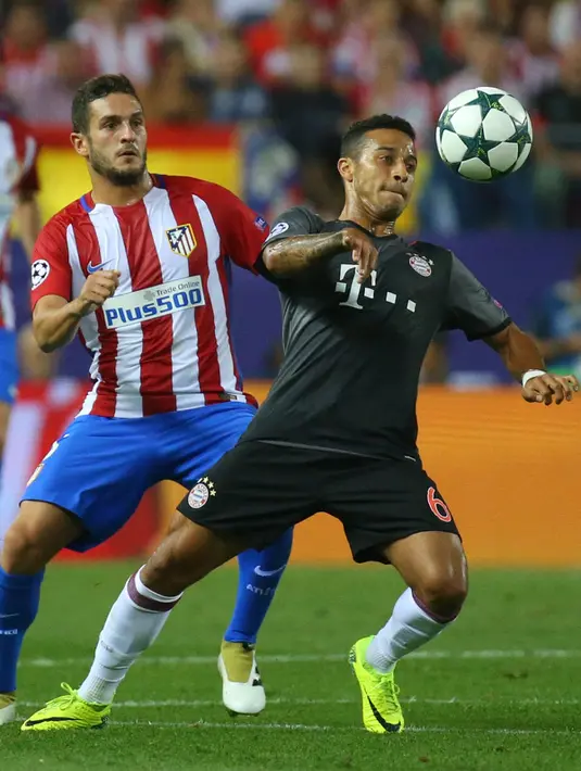 Gelandang Bayern Munich, Thiago Alcantara (kanan) berusaha mengontrol bola dari kawalan gelandang Atletico Madrid, Koke pada pertandingan Liga Champions di Madrid, Spanyol, (29/9). Atletico Madrid menang atas Bayern Munchen 1-0. (Reuters/Paul Hanna)