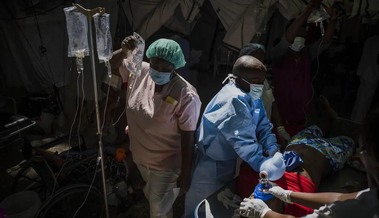 Seorang perawat membawa infus saat dokter mencoba menyelamatkan Stanley Joliva, seorang pasien dengan gejala kolera, di sebuah klinik yang dikelola oleh Doctors Without Borders di Port-au-Prince, Haiti, Kamis, 27 Oktober 2022. Untuk pertama kalinya dalam tiga tahun, orang-orang di Haiti telah sekarat karena kolera, meningkatkan kekhawatiran tentang skenario yang berpotensi menyebar cepat dan menghidupkan kembali ingatan tentang epidemi yang menewaskan hampir 10.000 orang satu dekade lalu. (AP/Ramon Espinosa)