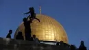 Siluet jamaah Muslim saat merayakan di depan masjid Dome of the Rock sebelum sholat Idul Fitri pagi, yang menandai akhir bulan suci Ramadhan, di kompleks masjid Al-Aqsa, di Yerusalem (13/5/2021). (AFP/Ahmad Gharabli)