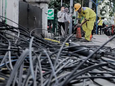 Petugas Dinas Bina Marga DKI Jakarta melakukan penataan kabel utilitas di sekitar Jalan Haji Agus Salim, Jakarta Pusat, Rabu (24/5/2023). (Liputan6.com/Herman Zakharia)