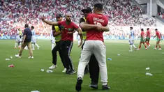 Petugas keamanan bekerja ekstra keras saat menangkap para suporter yang nekat menerobos lapangan saat Argentina berhadapan dengan Maroko pada laga grup B  Olimpiade Paris 2024. (AP Photo/Silvia Izquierdo)