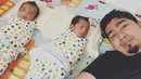Lucunya anak kembar ustaz Solmed dan Aprile Jasmine.Ustaz Solmed tiduran dan disampingnya kedua anak kembar yang lahir pada 4 Mei 2018 silam. Kedua anaknya berbalut kain bedong. (instagram/ustad_solmed)