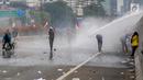 Mahasiswa mendapat semprotan air dari kendaraan water cannon polisi dalam demonstrasi menolak pengesahan RUU KUHP dan revisi UU KPK di depan Gedung DPR, Jakarta, Selasa (24/9/2019). Semprotan water cannon dan tembakan gas air mata memaksa mahasiswa mundur. (Liputan6.com/Faizal Fanani)