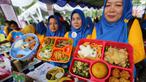 Orang tua siswa PAUD menunjukkan bekal sehat untuk anak pada Festival Gizi Anak yang digelar Danone Nutricia, Bogor, Selasa (30/1). Kegiatan ini digelar dalam rangka Hari Raya Gizi Nasional yang jatuh pada tanggal 25 Januari 2018 lalu. (Liputan6.com)