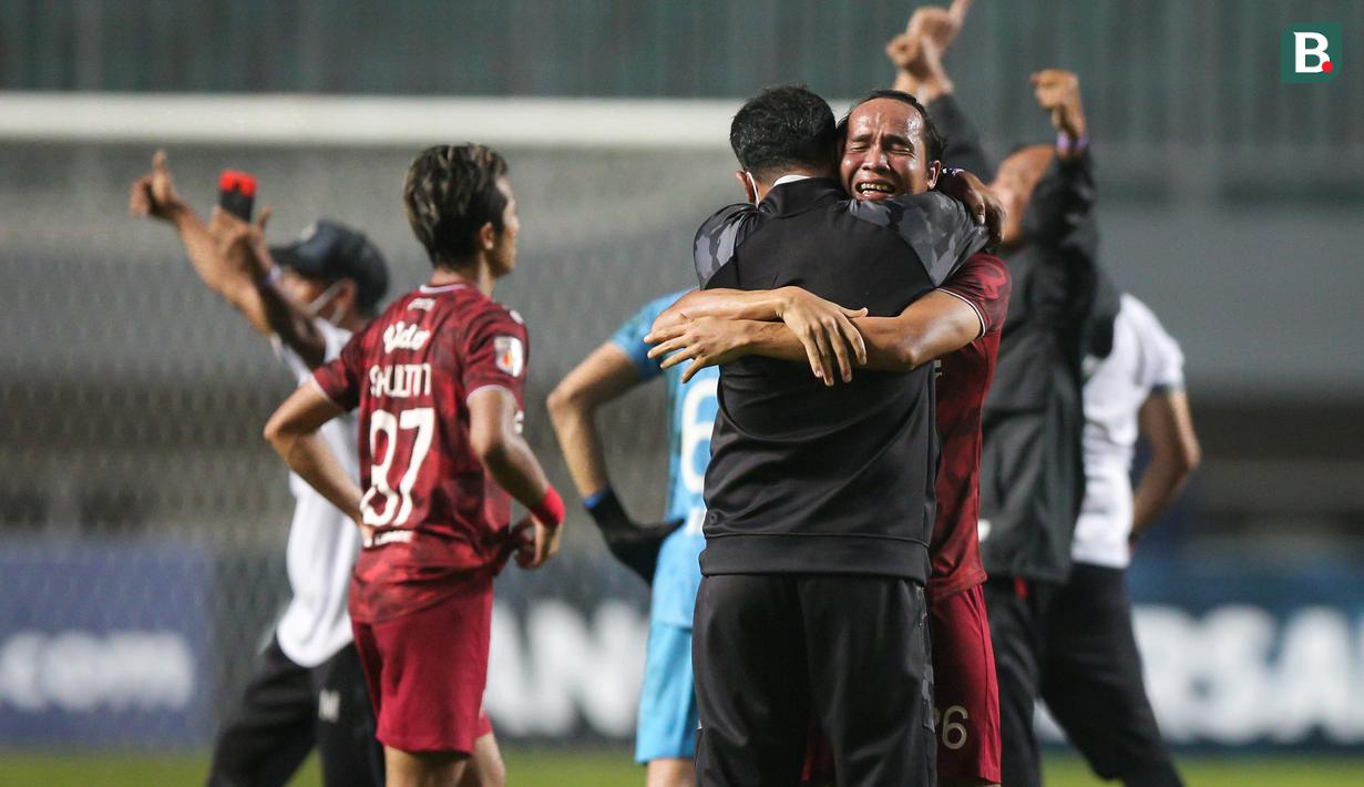 Pemain Persis Solo, Rian Miziar dan pelatih Eko Purdjianto berpelukan merayakan kemenangan 2-1 atas Martapura Dewa United usai berakhirnya laga semifinal Liga 2 2021 di Stadion Pakansari, Bogor, Senin (27/12/2021). (Bola.com/Bagaskara Lazuardi)