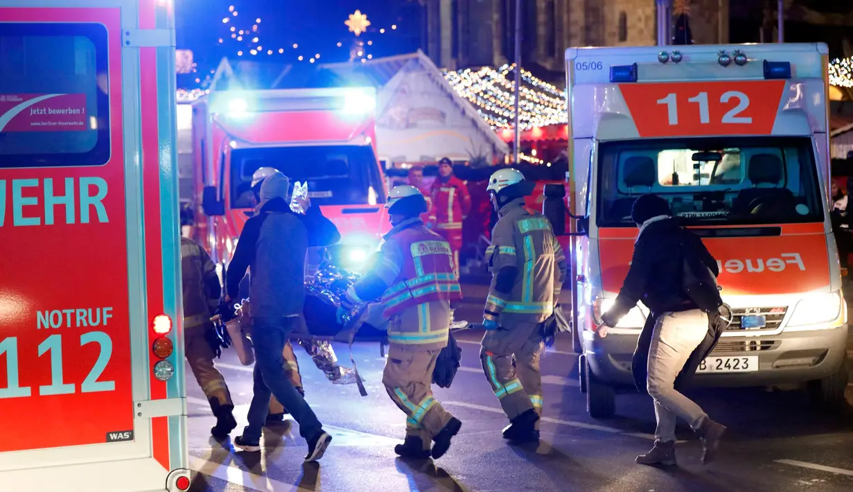 Tim regu penyelamat berada di lokasi dimana truk menabrak kerumunan orang di sebuah pasar Natal di pusat Kota Berlin, Jerman, Senin (19/12). Ambulan dan kendaraan aparat keamanan sesaat kemudian bermunculan di lokasi kejadian. (REUTERS/Pawel Kopczynski)