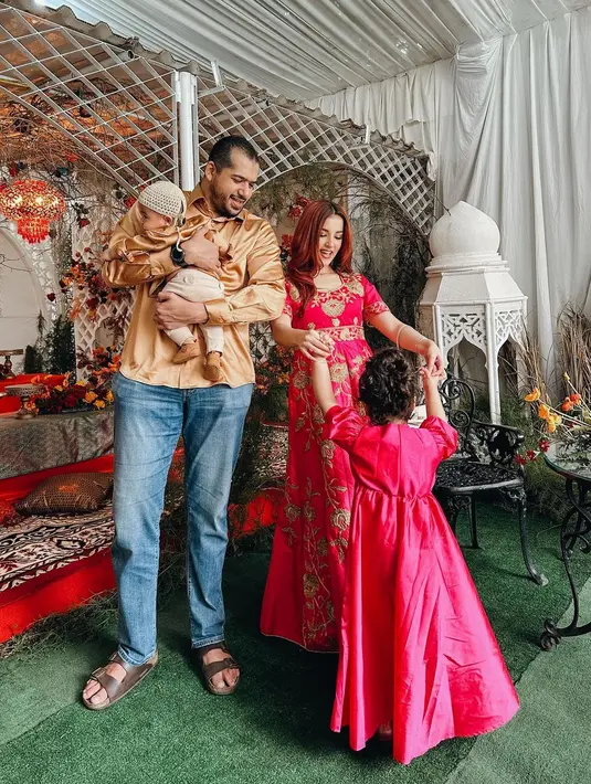Tasya Farasya tampil bak Arabian Princess di hari Lebaran ini. Ia mengenakan dress bernuansa fuchsia dengan bordir emas yang indah, serasi dengan putri pertamanya, sedangkan suami dan anak keduanya kompak mengenakan atasan berwarna emas dan celana jeans. Foto: Instagram.