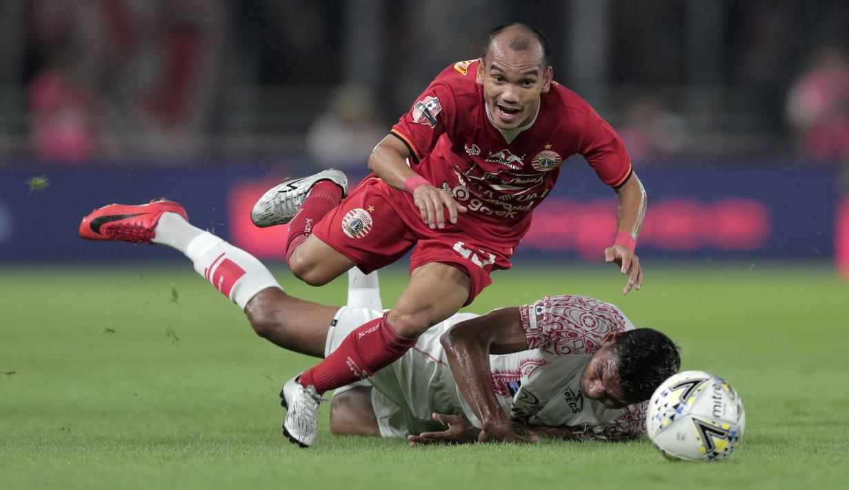 Gelandang Persija Jakarta, Riko Simanjuntak, berebut bola dengan pemain Persipura Jayapura pada laga Shopee Liga 1 di SUGBK, Senayan, Jakarta, Kamis (28/11). Persija menang 1-0 atas Persipura. (Bola.com/Yoppy Renato)