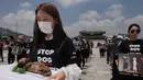 <p>Seorang aktivis dari kelompok 'Animal Liberation Wave' dan 'Last Chance for Animals' membawa anak anjing mati yang diambil dari peternakan daging anjing di Gwanghwamun Plaza, Seoul (7/7). Mereka memprotes perdagangan daging anjing. (AFP Photo/Ed Jones)</p>