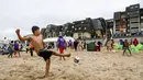 Seorang anak bermain sepak bola di pantai Cabourg, barat laut Prancis (18/8/2021). Acara ini sebagai bagian dari kampanye "Lupa Liburan" yang diselenggarakan oleh LSM Prancis Secours Populaire untuk anak-anak yang keluarganya tidak mampu pergi berlibur. (AFP/Sameer Al-Doumy)