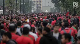 Ribuan suporter Timnas Indonesia beratribu merah putih mulai berdatangan di Stadion Gelora Bung Karno (GBK), Senayan, Jakarta, Minggu (14/1). Presiden Jokowi dijadwalkan bakal ikut menyaksikan pertandingan ini. (Liputan6/Faizal Fanani)