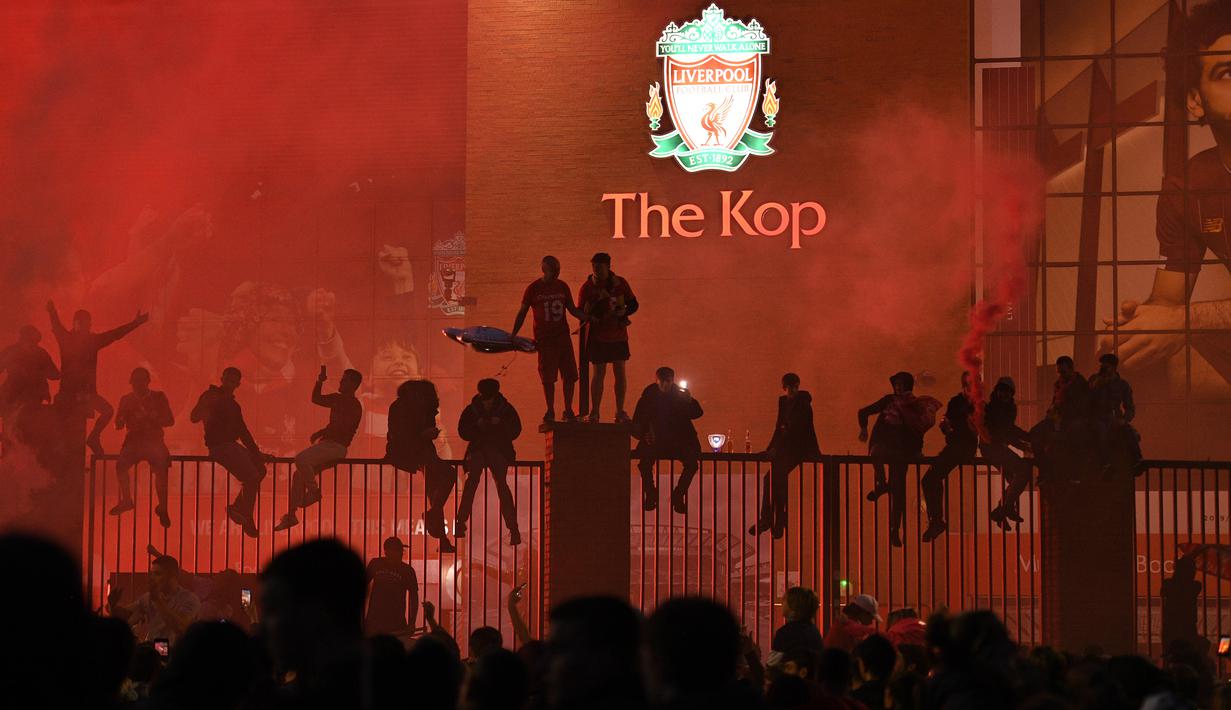 Fans Liverpool merayakan juara Premier League di area Standion Anfield usai pertandingan Liverpool melawan Chelsea, Kamis (23/7/2020) dini hari WIB. Fans Liverpool tetap berdatangan ke area Stadion Anfield meski ada permintaan untuk merayakan di rumah. (AFP/Oli Scarff)