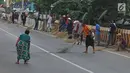 Warga berebut uang yang dilemparkan pengguna jalan menggunakan sapu di Jembatan Sewo, Indramayu, Jawa Barat, Senin (3/6/2019). Kehadiran pencari sedekah tersebut biasanya kian bertambah banyak saat menjelang arus mudik Lebaran. (Liputan6.com/Herman Zakharia)