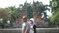 Wisatawan mengunjungi anjungan Provinsi Bali di Taman Mini Indonesia Indah (TMII), Jakarta, Minggu (21/6/2020). Setelah tidak beroperasi akibat pandemi, pengelola membuka kembali TMII dengan menerapkan protokol kesehatan pencegahan COVID-19 dan pembatasan pengunjung. (Liputan6.com/Immanuel Antonius)