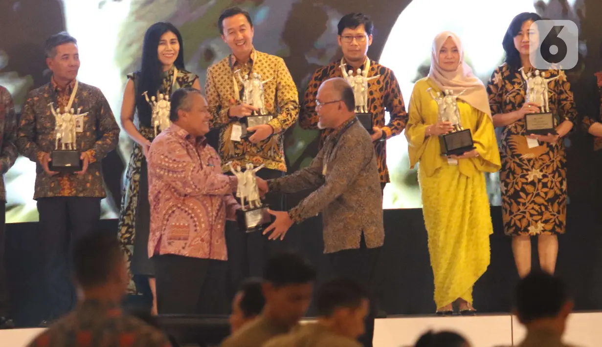 Gubernur BI Perry Warjiyo memberikan penghargaan BI Award 2019  kepada Presdir PT Toyota Motor Manufacturing Indonesia (TMMIN) Warih Andang Tjahjono dalam acara Pertemuan Tahunan Bank Indonesia (PTBI) 2019 di Jakarta, Kamis (28/11/2019). (Liputan6.com/Angga Yuniar)