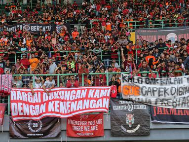 Suporter Persija Jakarta memasang spanduk protes saat pertandingan melawan Perseru Badak Lampung pada laga Liga 1 2019 di Stadion Patriot, Bekasi, Minggu (1/9). Persija takluk 0-1 dari Badak Lampung. (Bola.com/M Iqbal Ichsan)