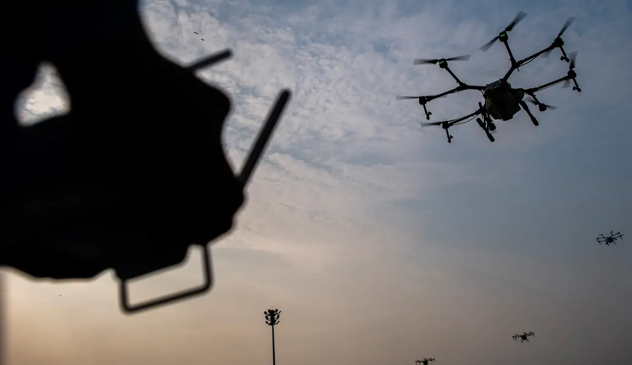 Relawan Administrasi Metropolitan Bangkok (BMA) menerbangkan drone untuk menurunkan hujan buatan pada demontrasi, Kamis (31/1). Thailand mengerahkan drone untuk menyemprotkan air dalam memerangi polusi udara di Ibu Kota yang makin parah. (Jewel SAMAD/AFP)