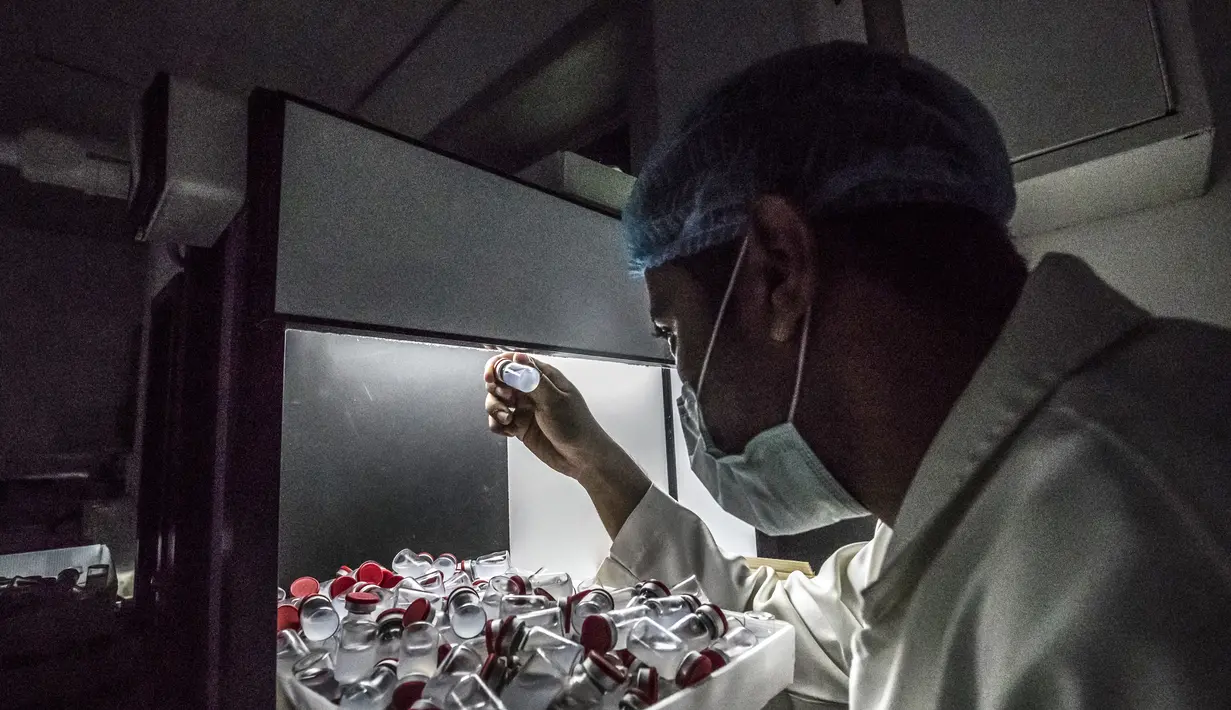 Pekerja laboratorium saat mengawasi produksi botol vaksin Sinovac di laboratorium Vacsera, Kairo, Mesir, Rabu (1/9/2021). Laboratorium Vacsera di Mesir membuat vaksin Sinovac China untuk mencegah penularan virus corona. (AFP/Khaled Desouki)