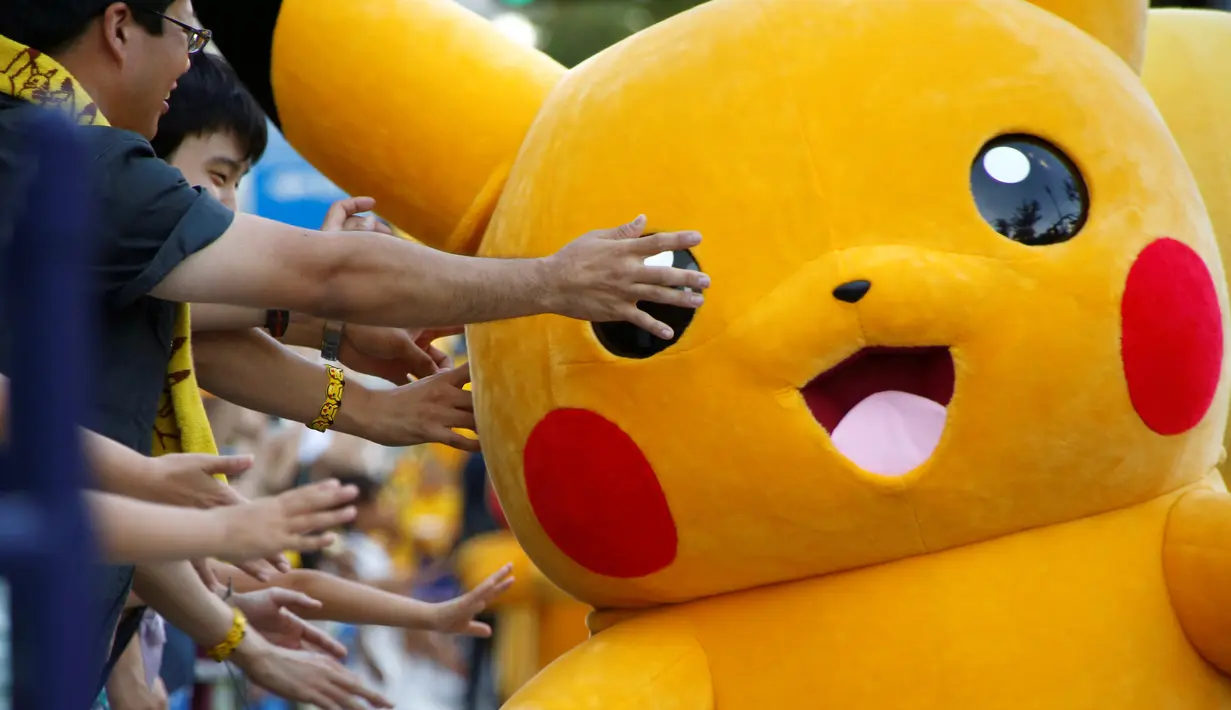 Warga bersuka cita menunggu parade Pikachu dalam serial animasi Pokemon melakukan parade di Yokohama , Jepang , 7 Agustus 2016. (REUTERS / Kim Kyung - Hoon)