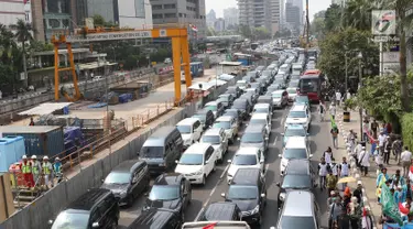 Kendaraan terjebak kemacetan di kawasan Bundaran HI, Jakarta, Rabu (6/9). Kemacetan parah terjadi akibat ribuan massa aksi yang menutup jalan saat unjuk rasa terkait solidaritas Rohingya di kantor Kedubes Myanmar. (Liputan6.com/Immanuel Antonius)