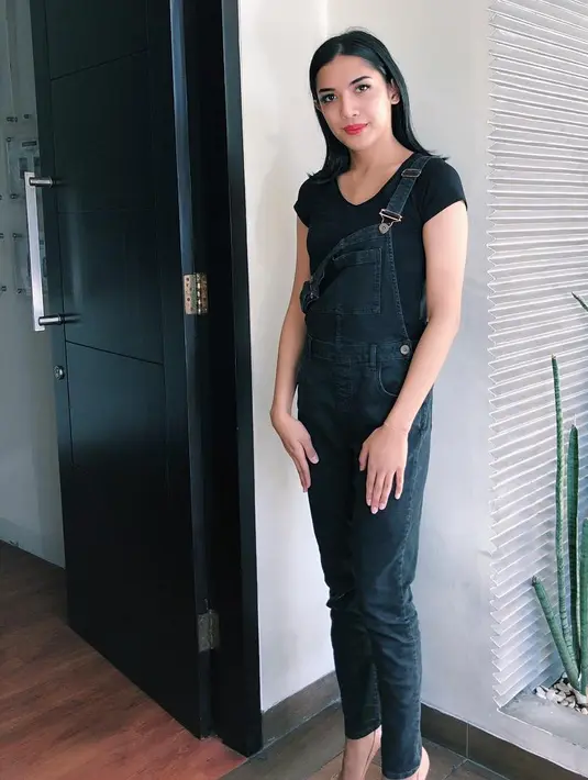 Selain seksi, Millen pun juga sering tampil casual. Outfit hitam dengan model baju overall dan kaos hitam ini membuat penampilannya sangat menawan. Terlebih ia memakai heels hitam saat itu. (Instagram/millencyrus)
