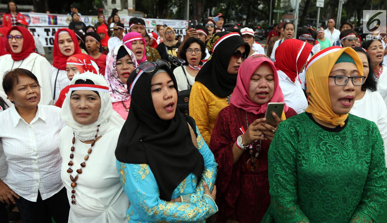 Relawan Indonesia Bersatu saat menggelar aksi potong tumpeng di depan Istana Negara, Jakarta, Jumat (5/7/2019). Aksi tersebut merupakan syukuran atas terpilihnya Joko Widodo atau Jokowi sebagai Presiden RI untuk kedua kalinya. (Liputan6.com/JohanTallo)