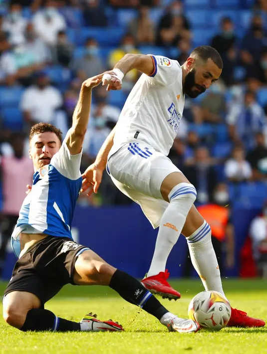 Pemain Real Madrid Karim Benzema (kanan) berebut bola dengan pemain RCD Espanyol Adria Pedrosa pada pertandingan La Liga Spanyol di Stadion Cornella-El Prat, Barcelona, Spanyol, Minggu (3/10/2021). Real Madrid kalah 1-2. (AP Photo/Joan Monfort)