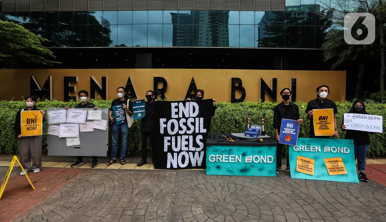 Aktivis yang tergabung dalam kampanye #bersihkanbankmu membawa poster saat aksi di depan kantor Bank Tabungan Negara (BNI), Jakarta, Jumat (17/6/2022). Dalam aksinya mereka mempertanyakan keseriusan Bank BI dalam penghentian pembiayaan proyek batu bara dan menyerukan untuk menghentikan praktek Greenwashing. (Liputan6.com/Johan Tallo)