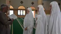Astrid Schorman bersama tiga putrinya mendengarkan penjelasan tentang Islam dari jamaah masjid A Yani Kota Malang, Jawa Timur (Zainul Arifin/Liputan6.com)