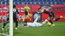 Bek Cagliari, Charis Lykogiannis (kanan) menjatuhkan striker AC Milan, Zlatan Ibrahimovic di dalam kotak penalti dalam laga lanjutan Liga Italia 2020/21 pekan ke-18 di Sardegna Arena, Senin (18/1/2021). Cagliari kalah 0-2 dari AC Milan. (AFP/Alberto Pizzoli)