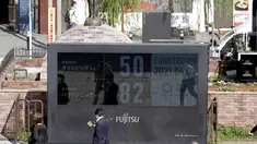Orang-orang berjalan di dekat jam hitung mundur untuk Olimpiade dan Paralimpiade Tokyo 2020 di dekat stasiun Shimbashi untuk menandai 50 hari sebelum dimulainya Olimpiade Musim Pana di Tokyo, Kamis (3/6/2021). (AP Photo/Kntaro Komiya)