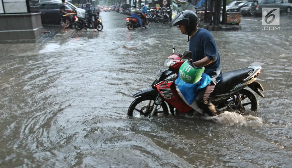 Pengandara sepeda motor melewati genangan air di kawasan Kemang, Jakarta Selatan, Kamis (18/10). Akibat hujan deras, kawasan di Jalan Kemang kembali tergenang air. (Liputan6.com/Herman Zakharia)