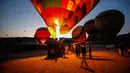 Wisatawan berkumpul saat balon udara disiapkan untuk menikmati pemandangan Kapadokia, Turki, Selasa (7/8). Cerobong Peri Kapadokia adalah lansekap batu vulkanik berbentuk kerucut yang menjulang tinggi ke langit. (AP Photo/Emrah Gurel)
