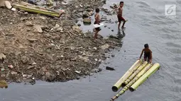 Anak-anak berenang menggunakan batang pohon pisang di bantaran Sungai Ciliwung, Jakarta, Selasa (15/5). Aktivitas tersebut berbahaya bagi kesehatan dan keselamatan mereka. (Liputan6.com/Immanuel Antonius)